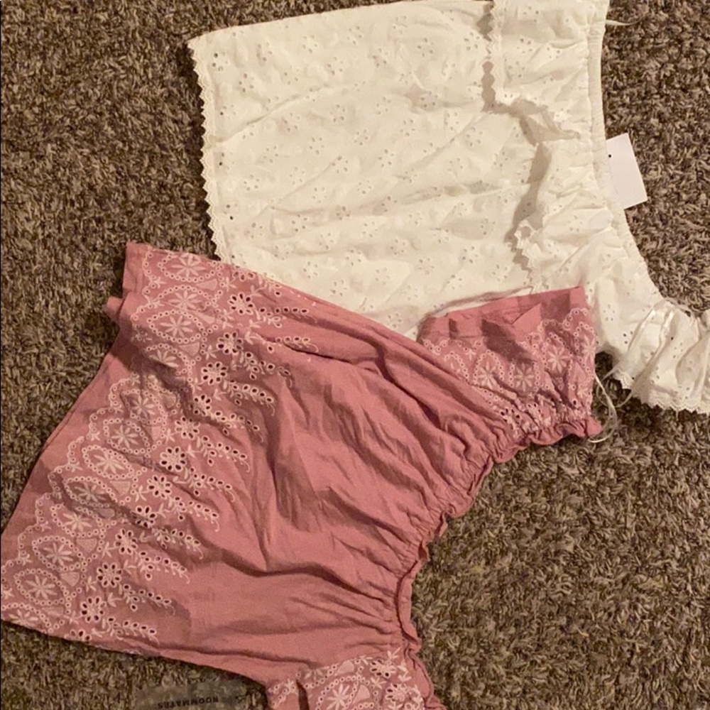 A pink and white shirt with flower looking detail